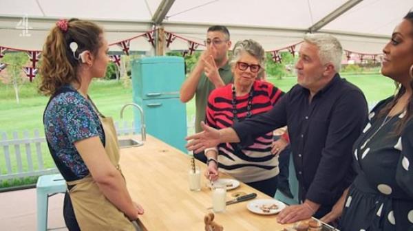 A photo of Paul Hollywood extending his hand to a Great British Bake Off co<em></em>ntestant in the Bake Off tent.